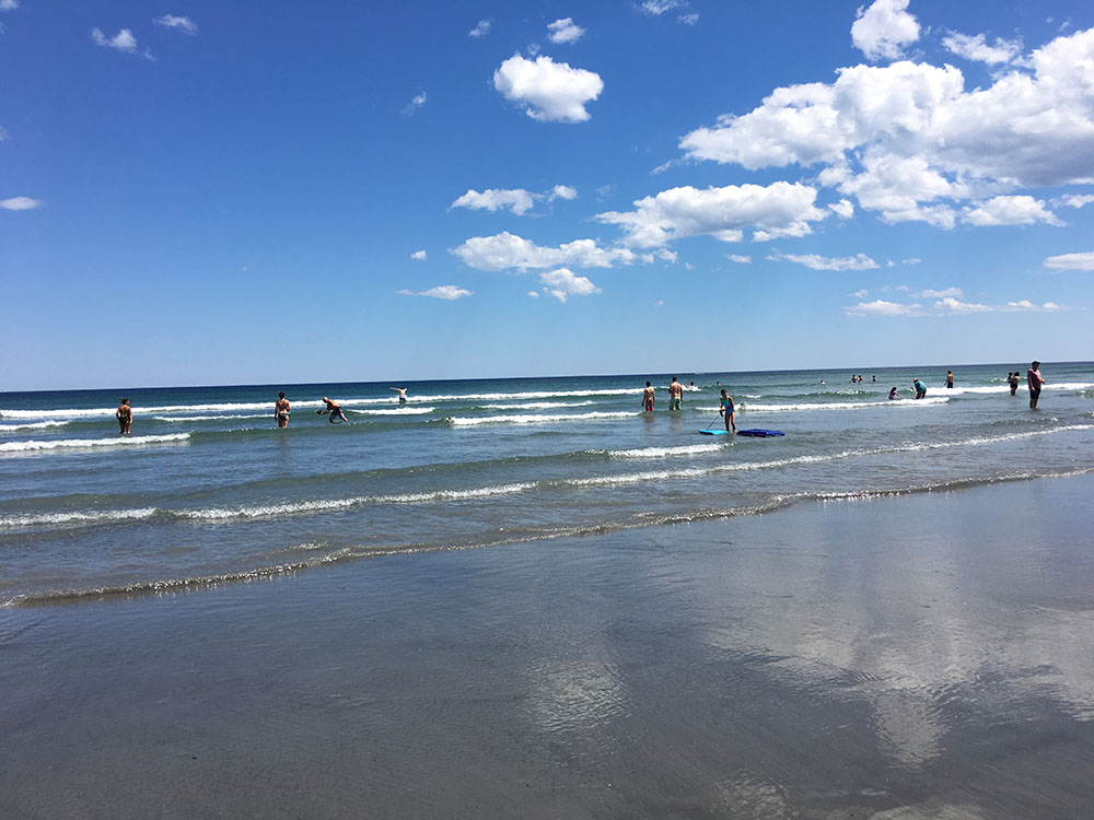 People swimming in water on Long Sands Beach.